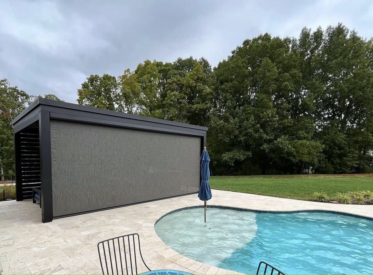 Large black motorized screen beside a residential swimming pool
